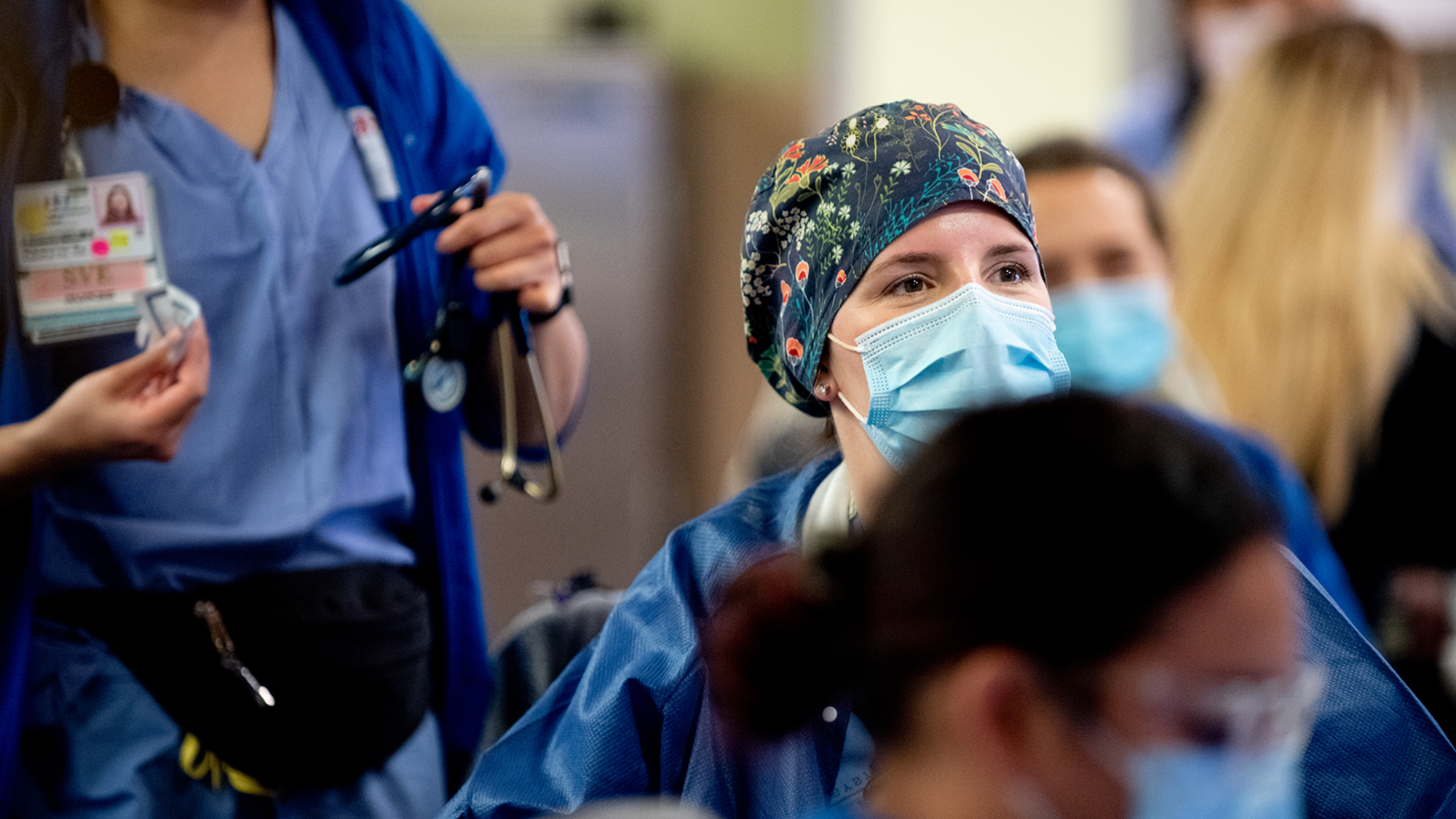 Nurse at desk with others around