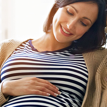 Pregnant seated woman smiling