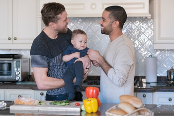 two men standing with baby 