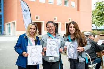 three staff members with caricatures on All Hands Day