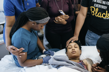 birthing person surrounded by community